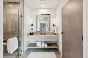 Bathroom featuring a stall shower, vanity, and recessed lighting