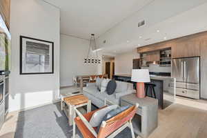 Living room with light wood-style flooring and recessed lighting