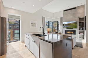 Kitchen with modern cabinets, stainless steel appliances, light wood-style floors, open floor plan, and dark stone counters