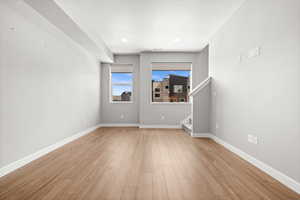 Unfurnished room featuring light wood-style flooring, stairway, and recessed lighting