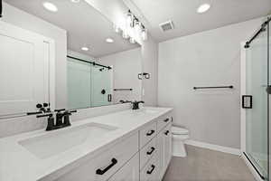 Full bath featuring a shower stall, double vanity, recessed lighting, and light tile patterned floors