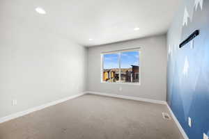 Carpeted empty room featuring baseboards and recessed lighting