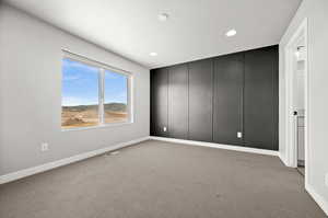 Unfurnished room with light colored carpet and recessed lighting