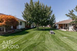 View of grassy yard with a patio