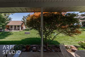 View of grassy yard with a patio area