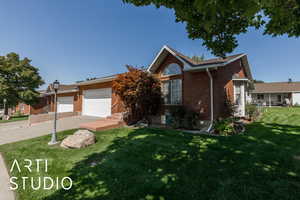 Ranch-style home featuring brick siding, a front yard, driveway, and a garage