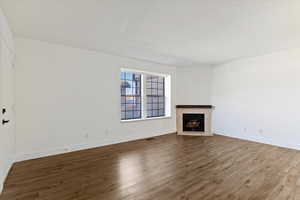 Unfurnished living room featuring a fireplace and wood finished floors