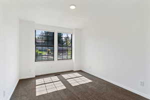 Carpeted empty room featuring baseboards