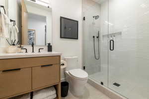 Bathroom with vanity, a stall shower, and tile patterned floors