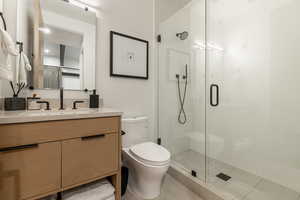 Full bath with vanity, a shower stall, and tile patterned floors