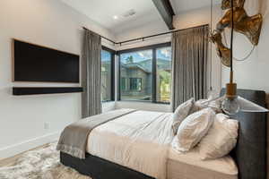 Bedroom with beamed ceiling and recessed lighting