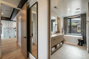 Bathroom featuring a freestanding tub, vanity, and wood finished floors