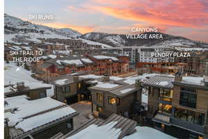 Snowy aerial view featuring a mountain view and a residential view