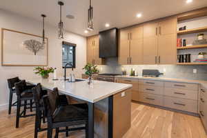 Kitchen with light wood-style floors, open shelves, backsplash, light stone countertops, and a breakfast bar area