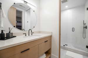 Bathroom featuring vanity, a stall shower, and recessed lighting