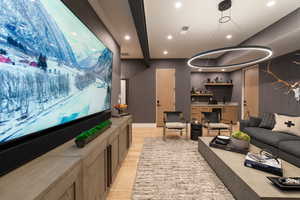 Home theater featuring light wood finished floors, recessed lighting, and bar