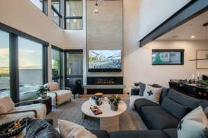 Living area featuring a high ceiling, a fireplace, and wood finished floors