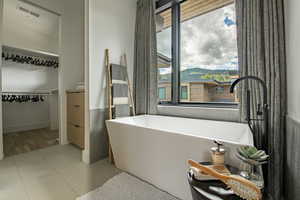 Bathroom featuring a freestanding bath and tile patterned flooring