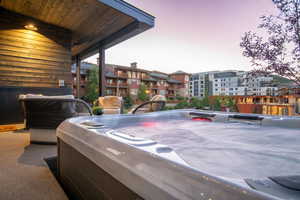 Patio terrace at dusk featuring a hot tub