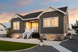 Back side of property with ceiling fan, covered porch, and stucco siding