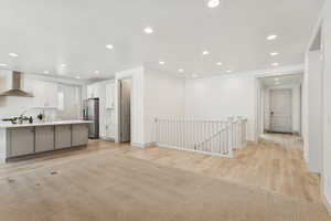 Kitchen featuring light countertops, light wood-style floors, recessed lighting, white cabinets, and gray cabinets