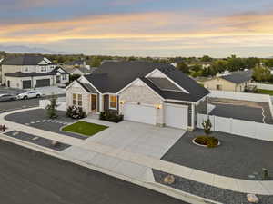 Traditional-style house featuring a residential view, driveway, stone siding, and a garage