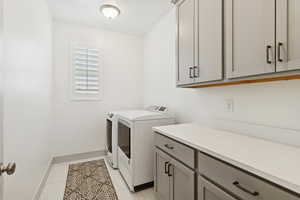 Washroom featuring washing machine and dryer and cabinet space