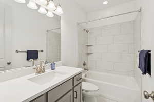 Bathroom with shower / bathtub combination and vanity.