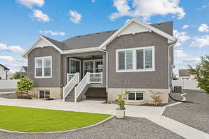 Back of house with a ceiling fan, stucco siding.