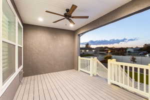 Deck at dusk featuring ceiling fan and a residential view