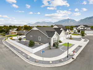 View of front and side of house with a mountain view, a residential view, driveway, and a garage