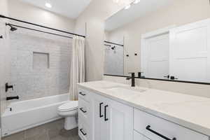 Full bathroom featuring shower / bathtub combination with curtain, vanity, dark tile patterned flooring, and recessed lighting