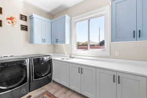 Washroom featuring washing machine and dryer and cabinet space