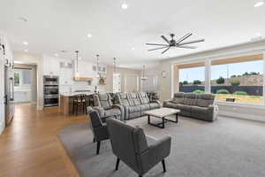 Living room with recessed lighting, a chandelier, and ceiling fan