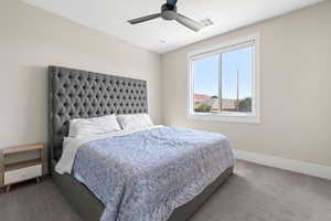 Carpeted bedroom featuring a ceiling fan and baseboards