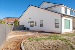 Back of property with stucco siding and a fenced backyard