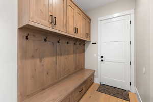 Mudroom featuring light wood-style floors and baseboards