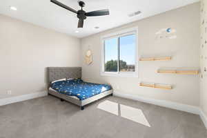 Carpeted bedroom featuring a ceiling fan and recessed lighting
