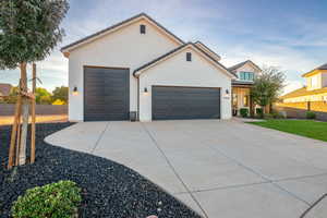 View of front of property with an attached garage, brick siding, and concrete driveway