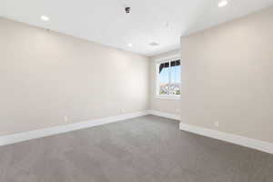 Carpeted empty room with recessed lighting and baseboards