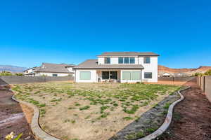 Back of house with a patio area, a mountain view, stucco siding, and a fenced backyard