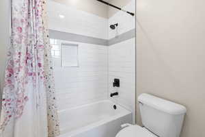Bathroom featuring shower / tub combo and toilet