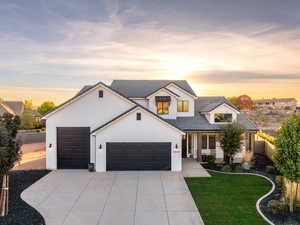 Modern inspired farmhouse with an attached garage, concrete driveway, stucco siding, and a tiled roof