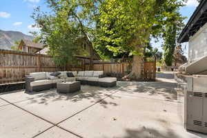 Fenced backyard with outdoor lounge area, a mountain view, and a patio area