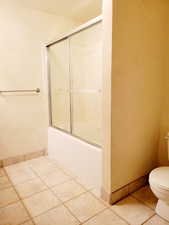 Full bath featuring enclosed tub / shower combo and tile patterned flooring