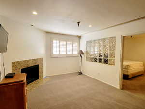 Unfurnished living room with carpet flooring, a premium fireplace, and recessed lighting