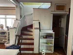 Stairs featuring wood finished floors connecting kitchen to sunny bedroom upstairs