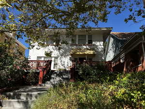 View of front of house with a wooden deck and stairway