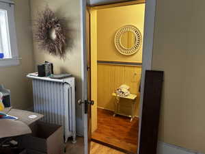 Interior space featuring radiator and wood finished floors a small 1/2 bath was added in the 90s