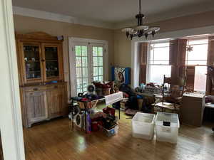 Dining area with light wood flooring and a chandelier, french doors to brick patio